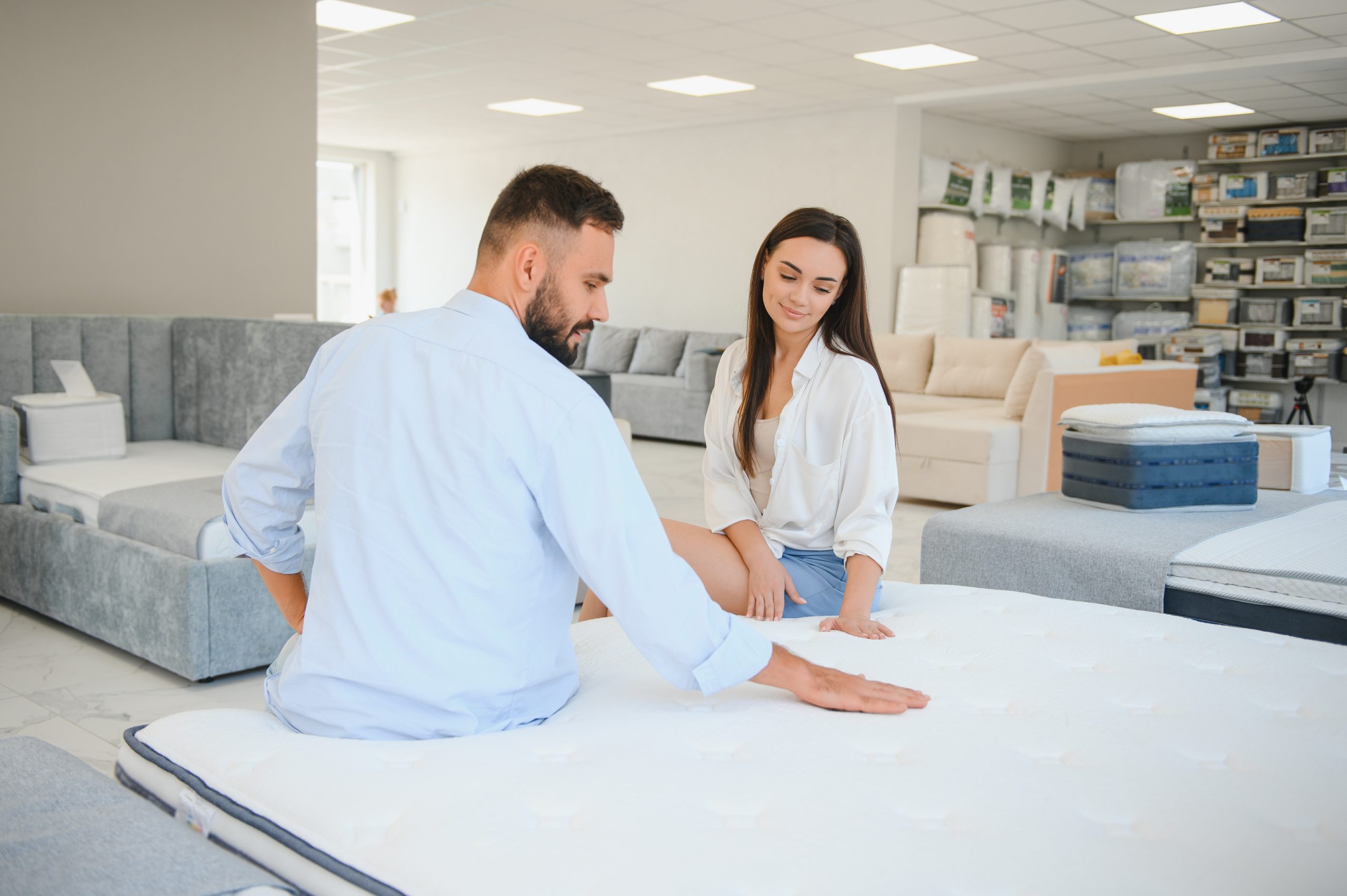 pareja eligiendo colchón en tienda de muebles