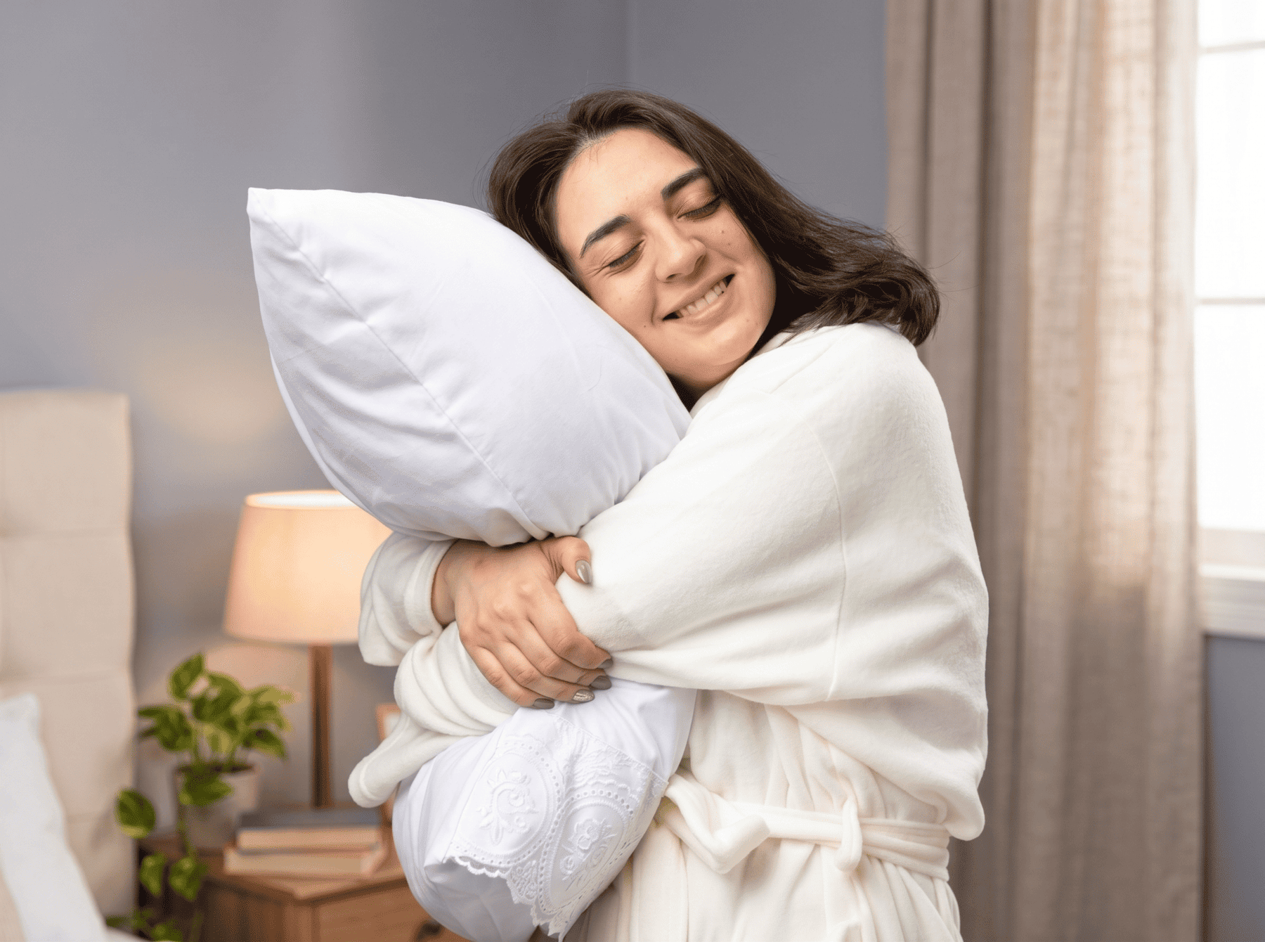 Joven abrazando una almohada, representando la importancia de elegir el soporte adecuado para dormir mejor.